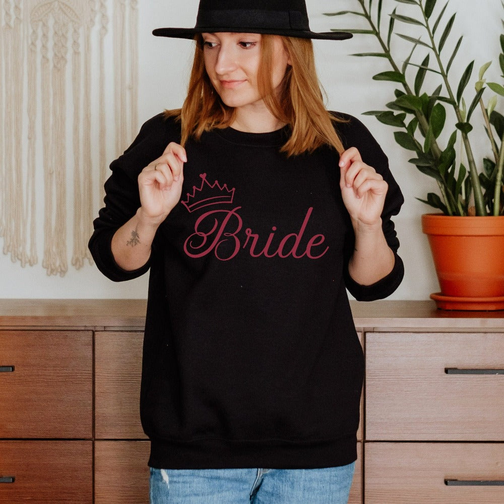 This cute bride sweatshirt is a great addition to getting ready for your wedding day. Serves as an engagement announcement surprise shirt; bachelorette party outfit; gift from bridesmaid or maid of honor; rehearsal night dinner outfit; and errand top for your wedding planning activities. So, if you have a soon to be bride, future Mrs. friend, or future daughter-in-law, this top is a great gift idea for her.