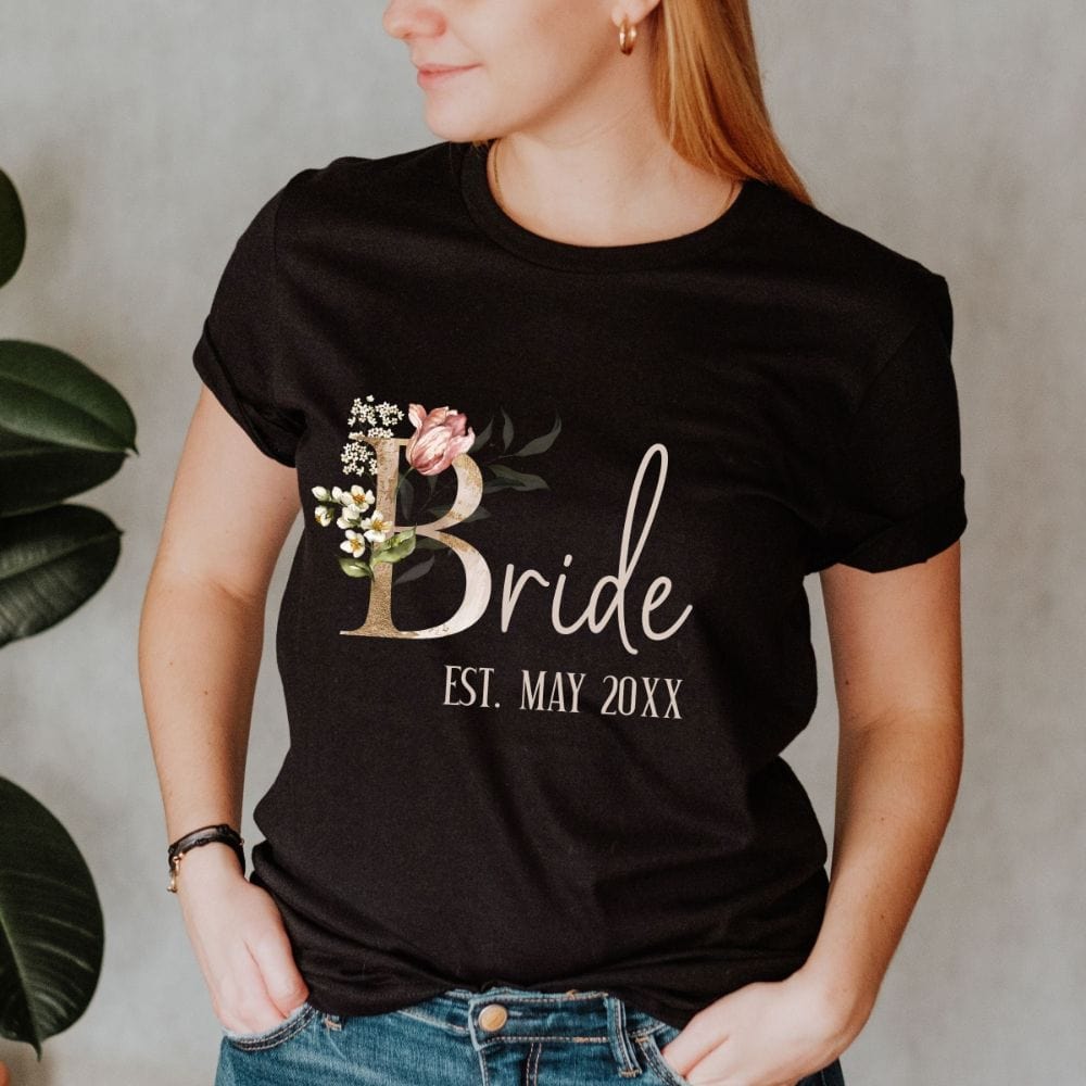 Customizable floral bride shirt for fiancée, wife, spouse, BFF or bestie on your wedding or anniversary. Great idea for engagement announcement, bachelorette party, bridesmaid gift idea, rehearsal dinner outfit, and after wedding party gift. This cute getting ready casual tee is a perfect idea for soon-to-be daughter-in-law, future Mrs. bride or as a honeymoon vacation souvenir. Personalize with date for a special touch.