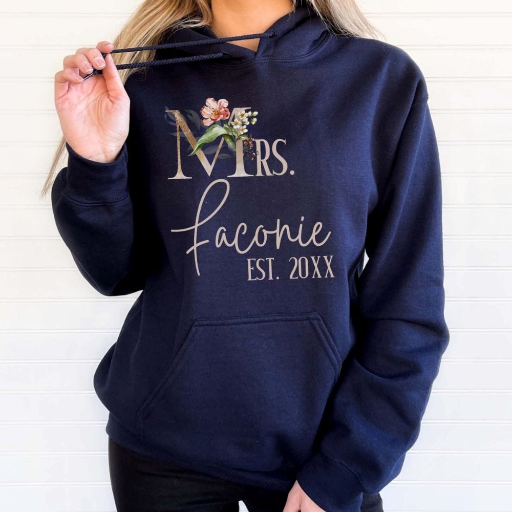 Customizable floral Mrs hoodie for fiancée, wife, spouse, BFF or bestie on your wedding or anniversary. Great idea for engagement announcement, bachelorette party, bridesmaid proposal box gift idea, rehearsal dinner, and after wedding party. This cute getting ready present is a perfect idea for soon-to-be daughter-in-law, future Mrs. bride or as a honeymoon vacation souvenir. Personalize with name and date for a special touch.